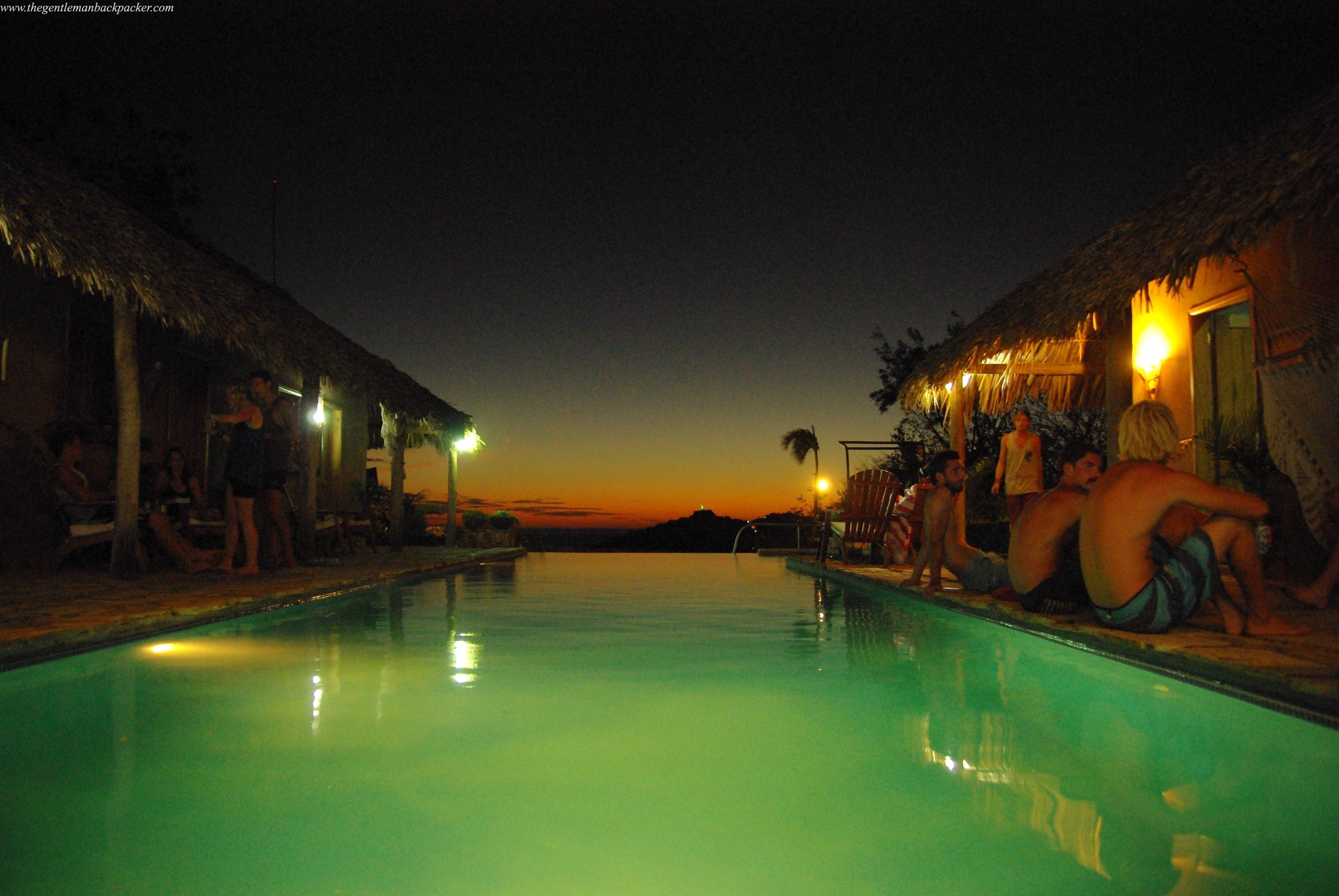 Socializing by the infinity pool at Casa de Olas, Statue of Christ in the distance